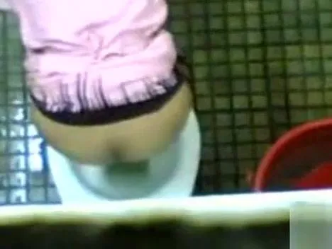 Urinating girl filmed over the bathroom wall