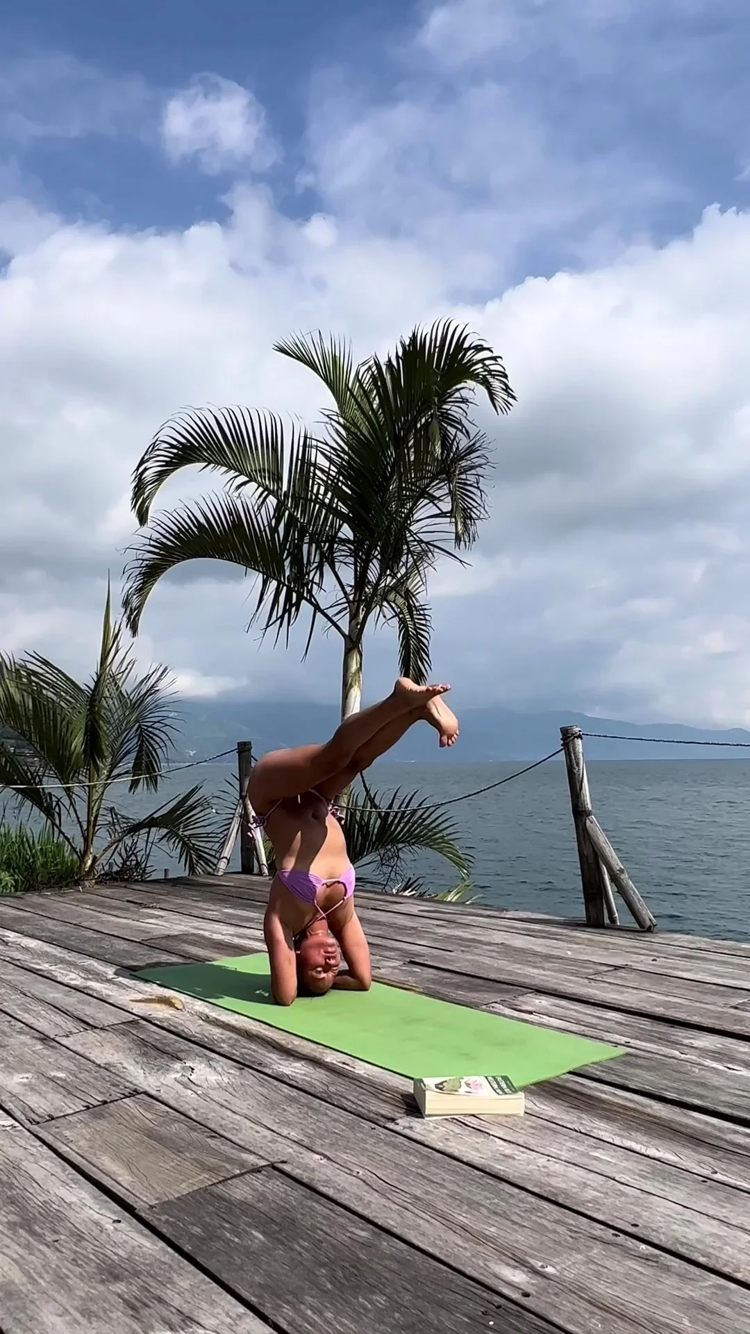 petite asian yoga instructor doing yoga at the lake while