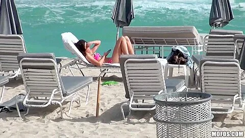 Beautiful and sexy dark-haired minx rests on the beach